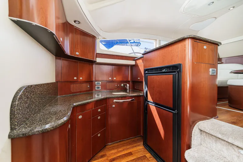 Slide: The Image of Luxurious 2005 Sea Ray 390 Motor Yacht interior with elegant wood cabinetry and modern amenities. - 28