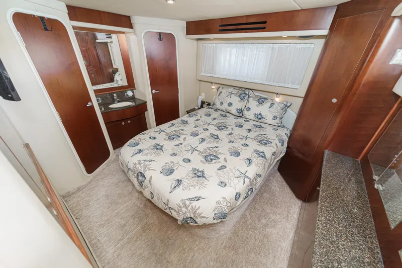 Slide: The Image of Luxurious 2005 Sea Ray 390 Motor Yacht bedroom with elegant wood finishes and cozy bedding. - 34