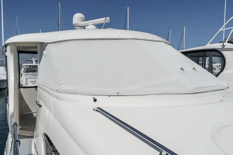 Slide: The Image of 2005 Sea Ray 390 Motor Yacht docked at marina, covered windshield, clear blue sky. - 7
