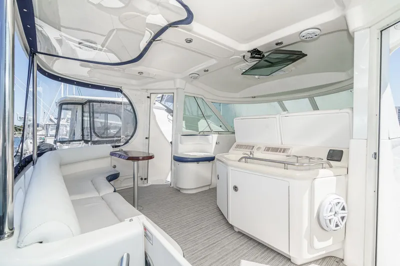 Slide: The Image of 2005 Sea Ray 390 Motor Yacht interior with white seating and kitchenette. - 9