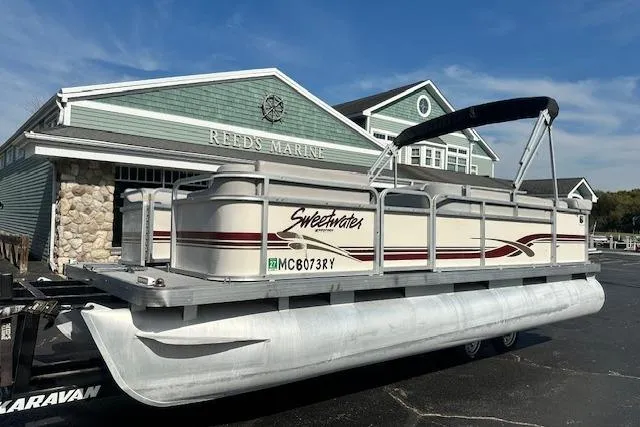 The Image of Sweetwater 2019 EL pontoon boat at Reeds Marine, parked on a trailer. - 1