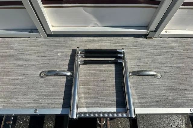 Slide: The Image of Sweetwater 2019 EL boat deck with foldable ladder, 2000 model, featuring metal handles. - 4