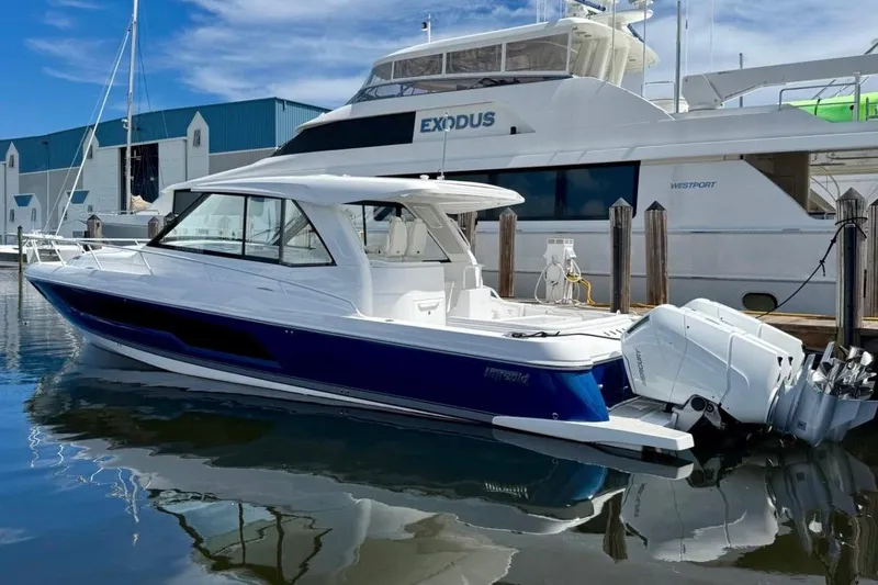 The Image of 2026 Intrepid 50 boat docked, featuring sleek design and powerful outboard engines. - 1