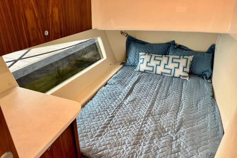 Slide: The Image of Cozy cabin interior of 2026 Intrepid 50 with blue bedding and large window. - 14