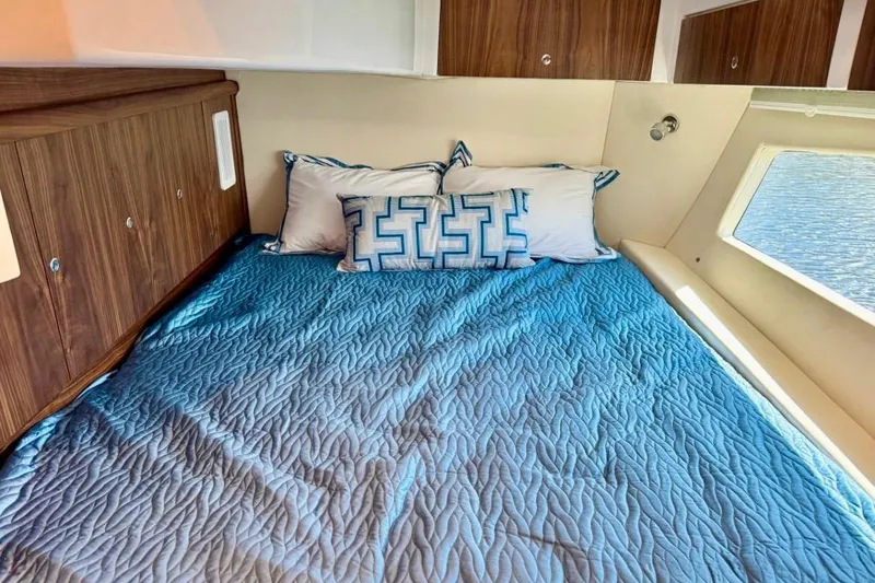Slide: The Image of Cozy cabin interior of 2026 Intrepid 50 with blue bedding and wooden cabinets. - 17