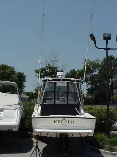 Slide: The Image of 2001 Carolina Classic 25 Classic boat named "Keeper" on display outdoors. - 2