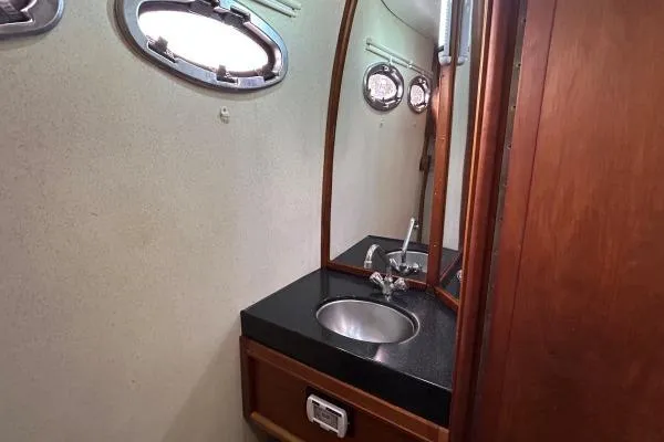 Slide: The Image of Bathroom interior of 2001 Crosswater Passagemaker 49 yacht with sink and porthole windows. - 17