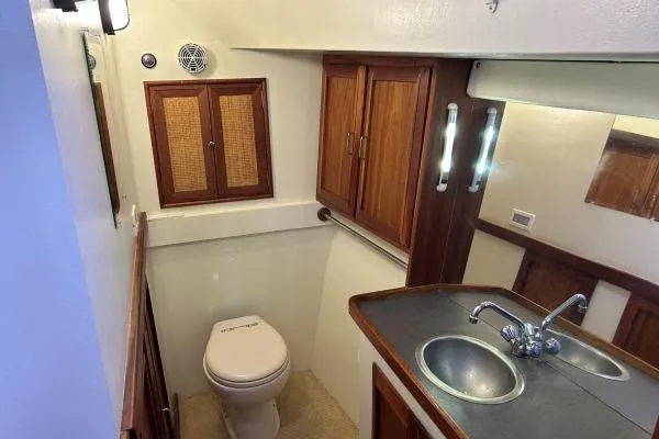 Slide: The Image of Bathroom interior of 2001 Crosswater Passagemaker 49 with wooden cabinets and sink. - 18