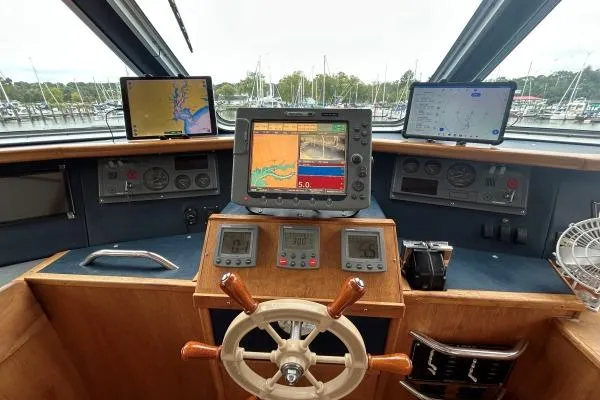 Slide: The Image of Helm of 2001 Crosswater Passagemaker 49 with navigation screens and wooden steering wheel. - 24