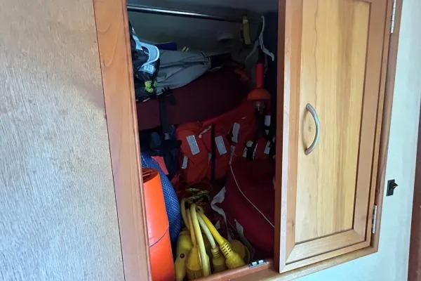 Slide: The Image of Storage compartment on a 2001 Crosswater Passagemaker 49, filled with life jackets and boating gear. - 43