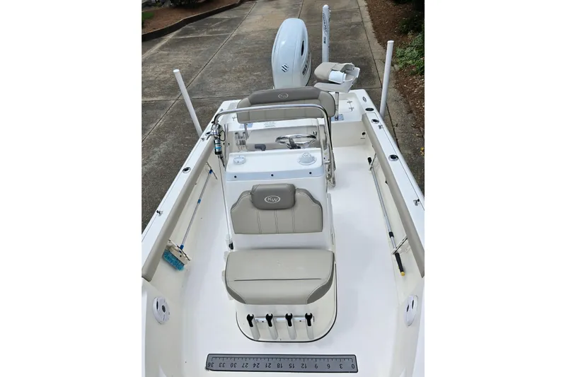 Slide: The Image of 2023 Key West 188 Bay Reef boat interior with seating and console, parked on pavement. - 22