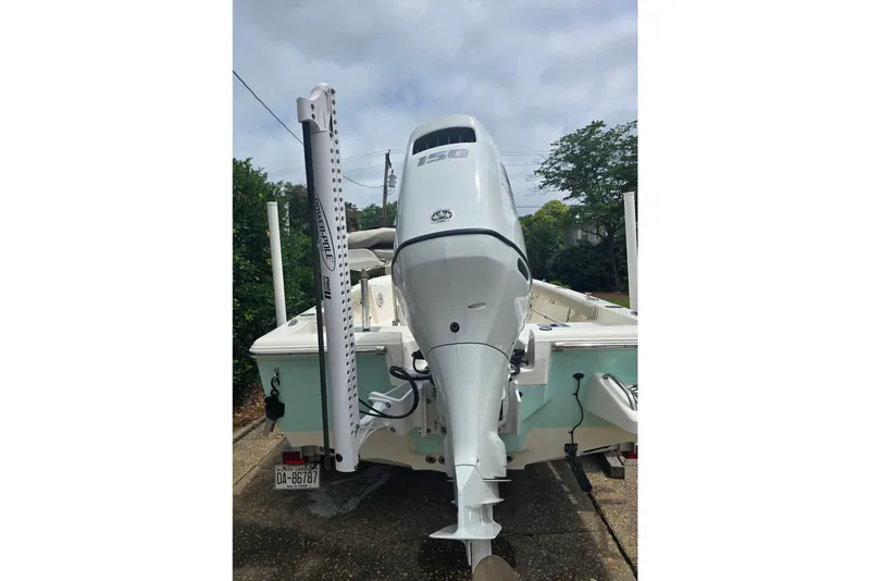 Slide: The Image of 2023 Key West 188 Bay Reef boat with powerful outboard motor, parked on a driveway. - 8