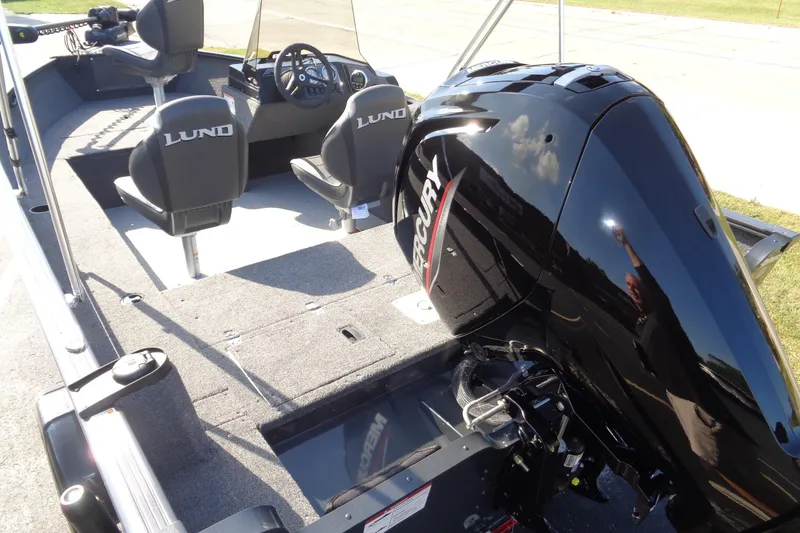 Slide: The Image of 2026 Lund 1650 Rebel XL SS boat interior with Mercury engine, featuring comfortable seating and steering console. - 16