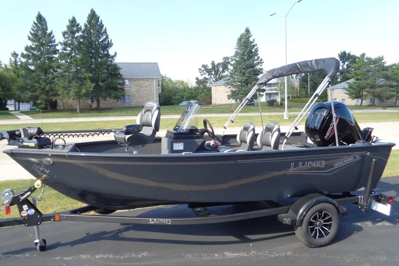 Slide: The Image of 2026 Lund 1650 Rebel XL SS boat on trailer, parked outdoors. - 18
