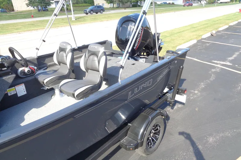 Slide: The Image of 2026 Lund 1650 Rebel XL SS boat with dual seats and Mercury engine, parked outdoors. - 19