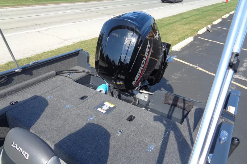 Slide: The Image of 2026 Lund 1650 Rebel XL SS boat with Mercury outboard motor, parked on pavement. - 24