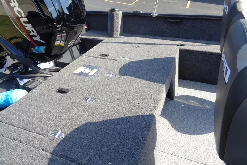 Slide: The Image of 2026 Lund 1650 Rebel XL SS boat interior with Mercury engine, featuring carpeted deck and seating. - 31