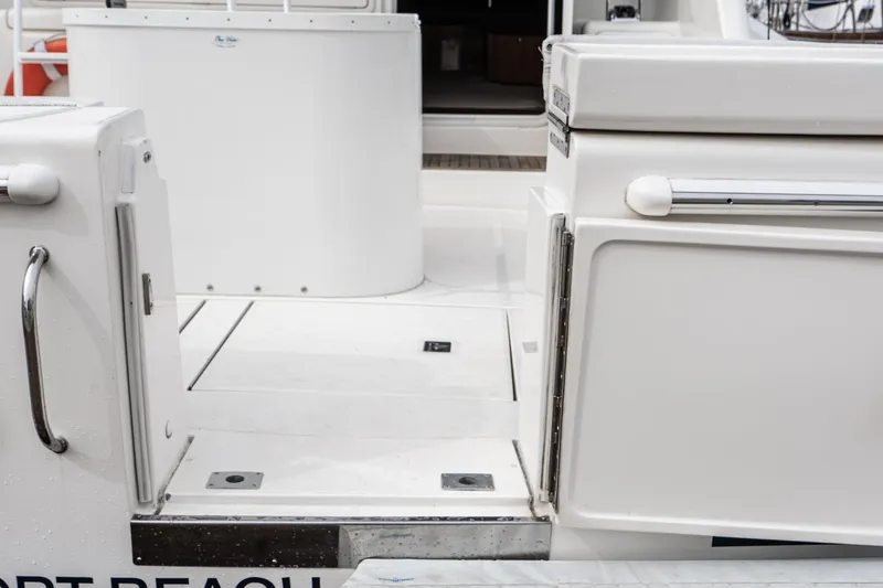 Slide: The Image of 2009 Riviera 47 Open Flybridge Series II yacht deck, featuring sleek white design and stainless steel accents. - 25