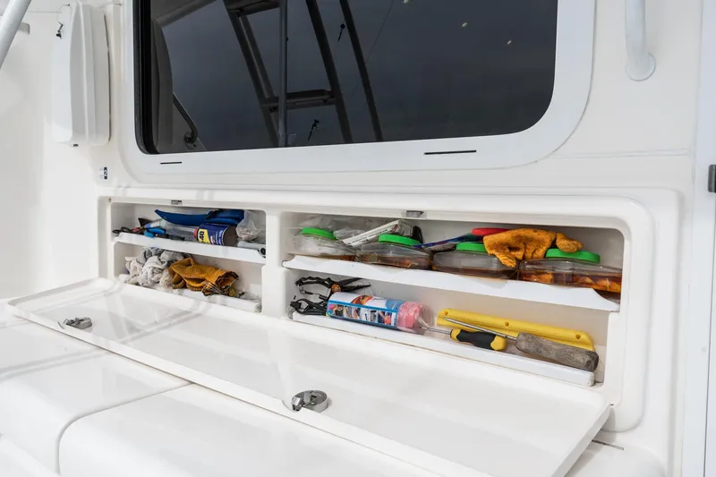 Slide: The Image of Storage compartments on a 2009 Riviera 47 Open Flybridge Series II boat, filled with tools and supplies. - 33