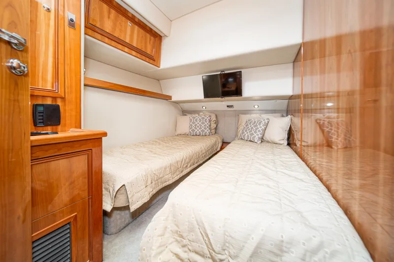 Slide: The Image of Interior of 2009 Riviera 47 Open Flybridge Series II with twin beds and wooden cabinetry. - 50