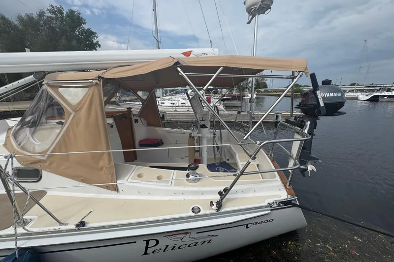Slide: The Image of 2007 Tartan 3400 sailboat docked, featuring tan canopy and Yamaha outboard motor. - 2