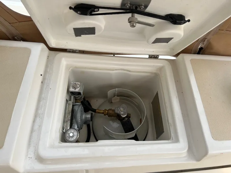 Slide: The Image of Open storage compartment on 2007 Tartan 3400 boat, showing gas cylinder and fittings. - 31