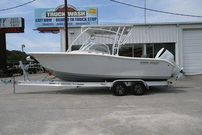 The Image of 2026 Sea Pro 240 Dual Console Deluxe boat on trailer outside a truck wash. - 1