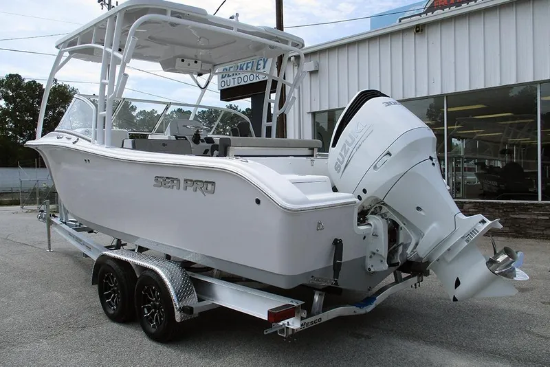 Slide: The Image of 2026 Sea Pro 240 Dual Console Deluxe boat on trailer, featuring Suzuki outboard motor. - 2