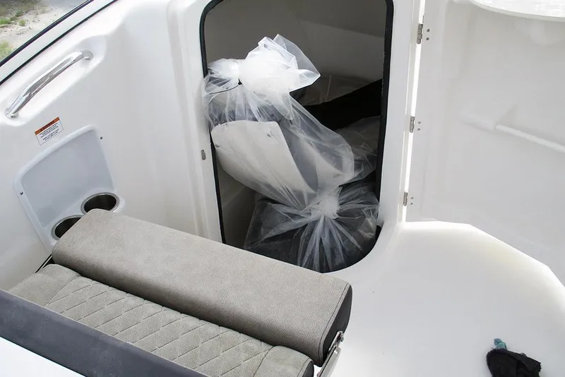 Slide: The Image of 2026 Sea Pro 240 Dual Console Deluxe interior with storage compartment and seating. - 26