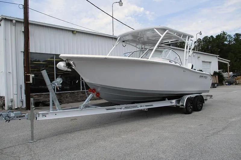 Slide: The Image of 2026 Sea Pro 240 Dual Console Deluxe boat on trailer outside a warehouse. - 3