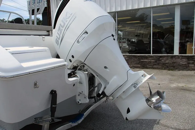 Slide: The Image of 2026 Sea Pro 240 Dual Console Deluxe with Suzuki outboard motor, parked outside showroom. - 9