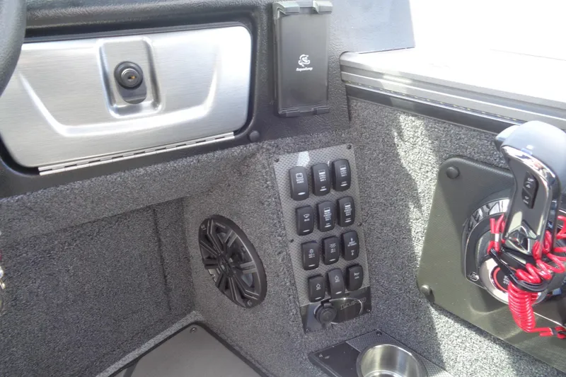 Slide: The Image of Interior controls of 2026 Lund 2075 Pro-V Sport boat, featuring switches and speaker. - 13