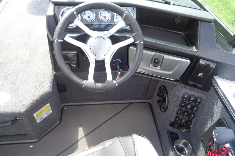Slide: The Image of 2026 Lund 2075 Pro-V Sport boat dashboard with steering wheel and control panel. - 15