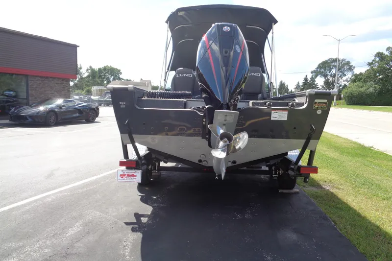 Slide: The Image of 2026 Lund 2075 Pro-V Sport boat with powerful outboard motor, parked on a sunny day. - 4