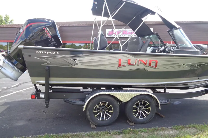 Slide: The Image of 2026 Lund 2075 Pro-V Sport boat on trailer, featuring sleek design and powerful engine. - 6