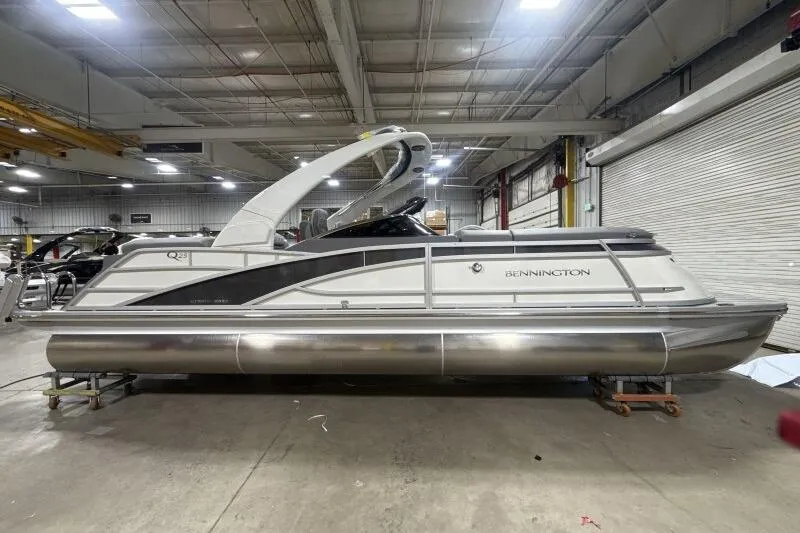 The Image of 2024 Bennington 25QFBWA pontoon boat in a warehouse setting. - 0