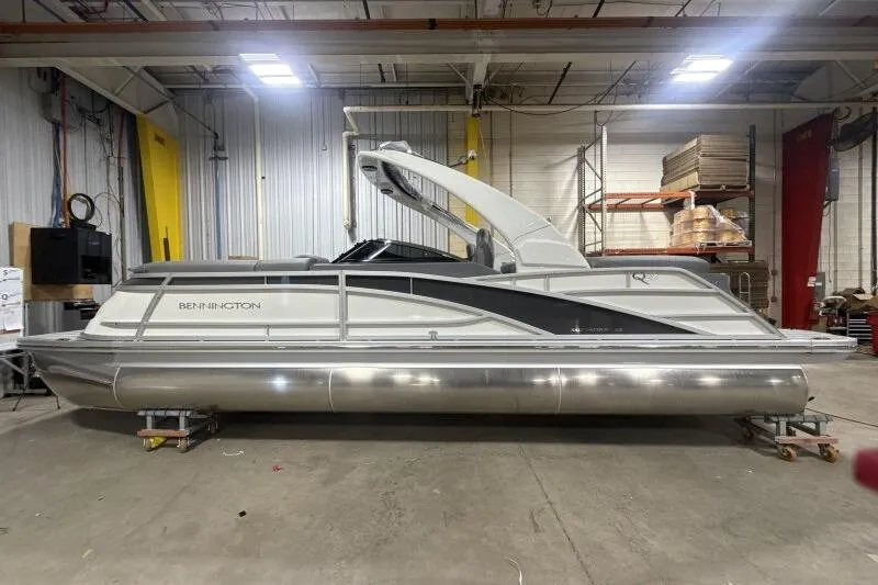 Slide: The Image of 2024 Bennington 25QFBWA pontoon boat in a warehouse setting. - 8