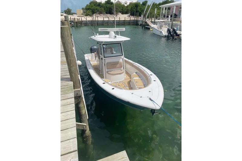 Slide: The Image of 2020 Sportsman Open 282 Center Console boat docked in clear water. - 1