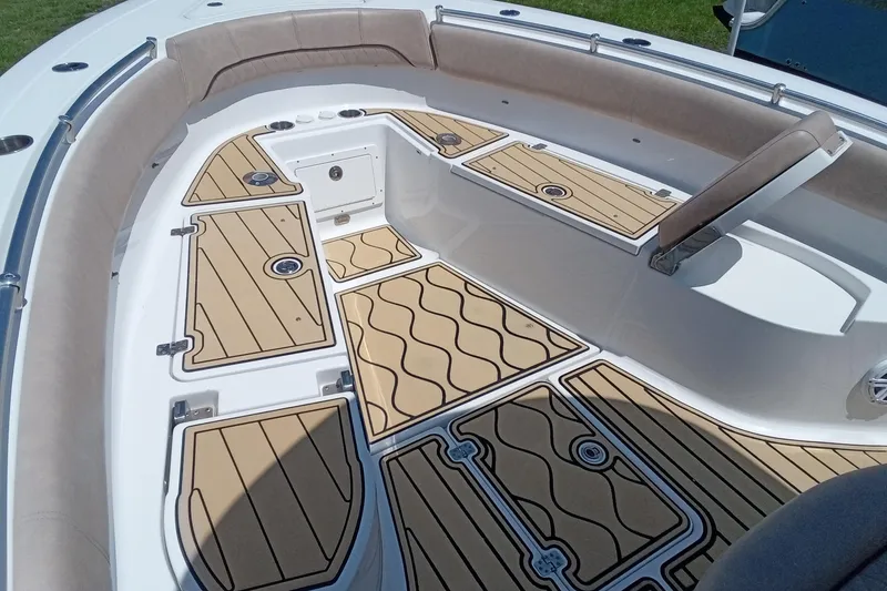 Slide: The Image of 2020 Sportsman Open 282 Center Console boat interior with cushioned seating and teak-style flooring. - 11