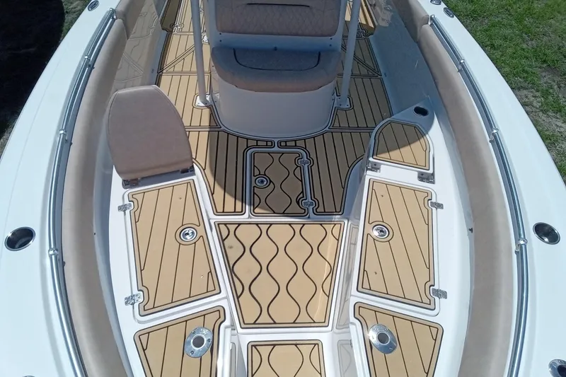 Slide: The Image of 2020 Sportsman Open 282 Center Console boat interior with teak flooring and cushioned seating. - 13