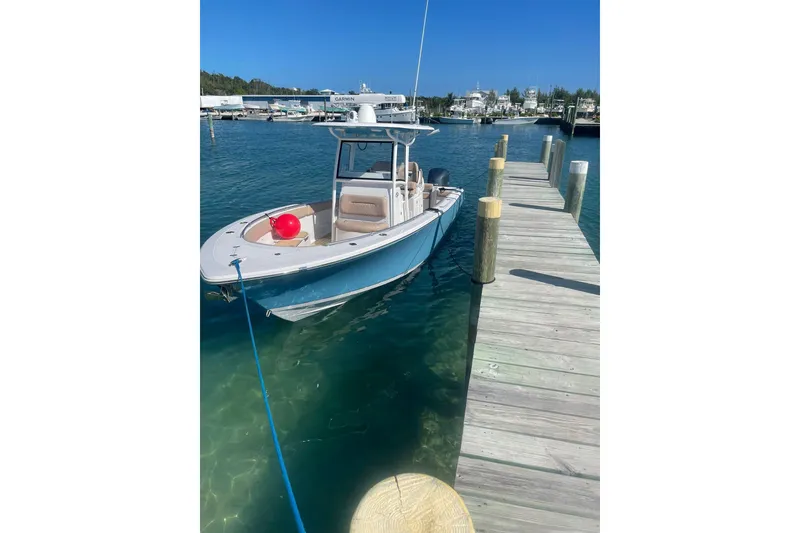 Slide: The Image of 2020 Sportsman Open 282 Center Console boat docked at a marina on a sunny day. - 2