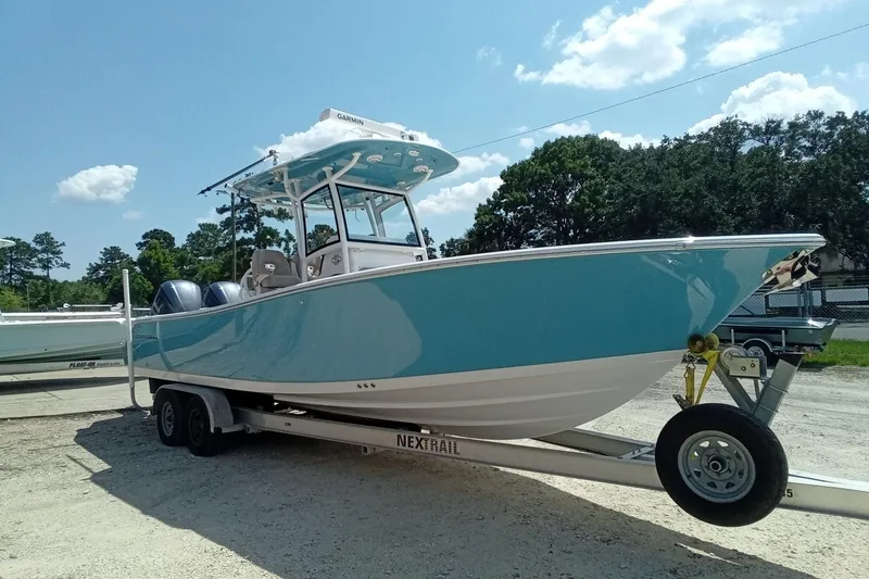 Slide: The Image of 2020 Sportsman Open 282 Center Console boat on trailer, parked outdoors under blue sky. - 32