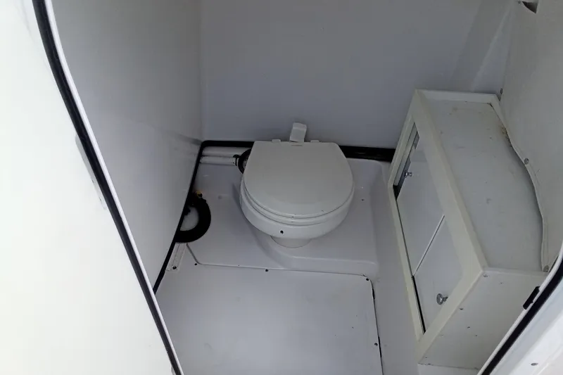 Slide: The Image of 2020 Sportsman Open 282 Center Console boat interior with compact marine toilet. - 8