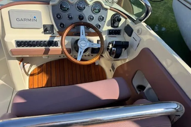 Slide: The Image of 2019 Chris-Craft Launch 30 cockpit with Garmin navigation, wooden steering wheel, and control panel. - 9