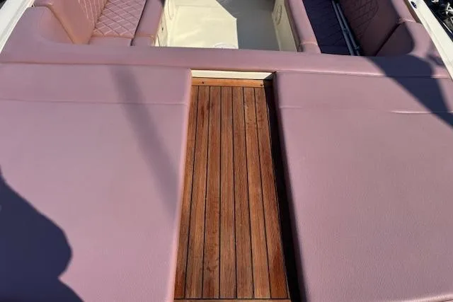 Slide: The Image of 2019 Chris-Craft Launch 30 boat interior with pink seating and wooden deck. - 7