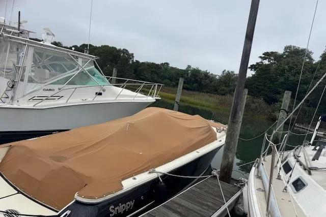 Slide: The Image of 2019 Chris-Craft Launch 30 boat with cover, docked between other boats. - 3