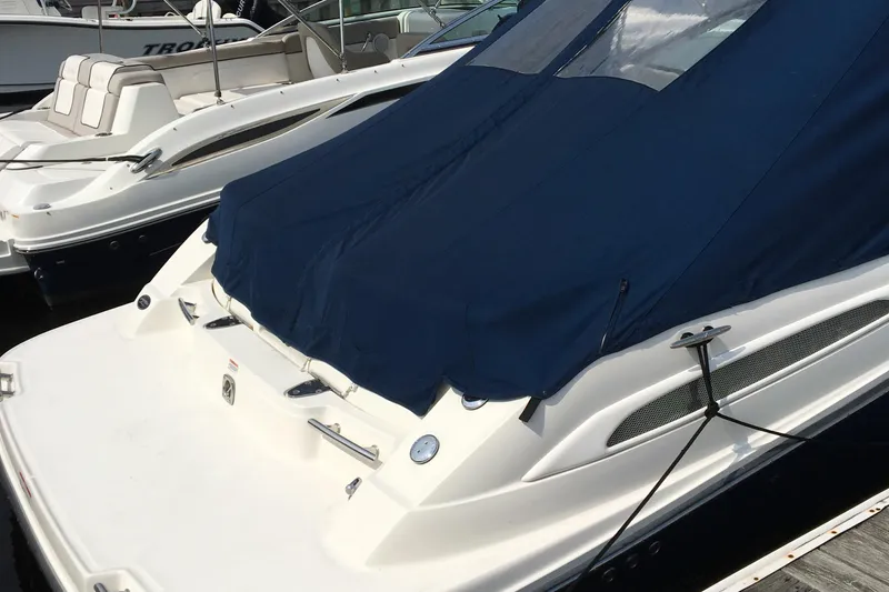 Slide: The Image of 2008 Sea Ray 270 SLX boat with blue cover docked at marina. - 2