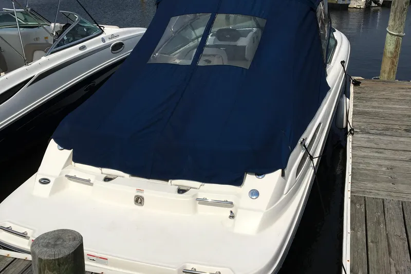Slide: The Image of 2008 Sea Ray 270 SLX boat docked with blue cover, rear view. - 3