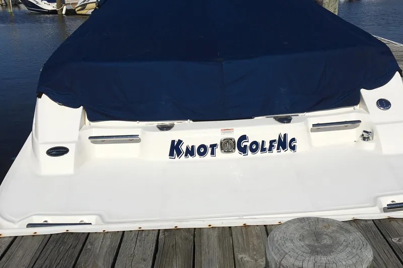 Slide: The Image of 2008 Sea Ray 270 SLX boat with blue cover, docked, featuring "Knot Golfing" name. - 4