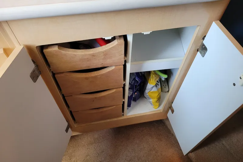 Slide: The Image of Open cabinet with wooden drawers and storage space in a 2001 Bayliner 2655 Ciera. - 11